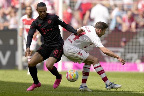 Bayern's Leroy Sane, left, and Cologne's Jonas Hector challenge for the ball during the German Bundesliga soccer match between 1. FC Cologne and FC Bayern Munich in Cologne, Germany, Saturday, May 27, 2023. (AP Photo/Matthias Schrader)