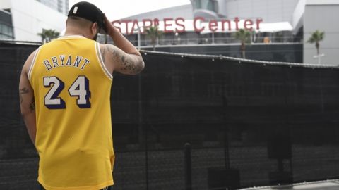 Gennesys Cabral, of Los Angeles, wears a Kobe Bryant jersey outside of the Staples Center at the 62nd annual Grammy Awards on Sunday, Jan. 26, 2020, in Los Angeles. Bryant died Sunday in a helicopter crash near Calabasas, Calif. He was 41. (AP Photo/Chris Pizzello)