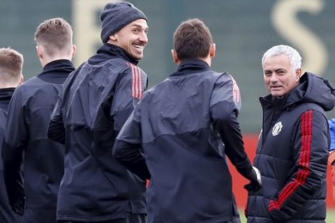 Manchester United's Zlatan Ibrahimovic, center, smiles with manager Jose Mourinho and teammates during a training session at the AON Training Complex, Carrington, England, Tuesday Nov. 21, 2017. (Martin Rickett/PA via AP)