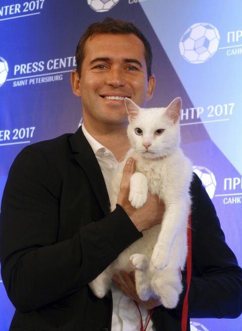 Zenit's soccer player Aleksandr Kerzhakov holds white colored and blue eyes 1, 5 years old cat named Achilles at a news conference in St. Petersburg, Russia, Thursday, June 15, 2017. Achilles was chosen by the Hermitage Museum to work as a foreteller of the results of the soccer matches at the Confederations Cup. (AP Photo/ Irina Titova)