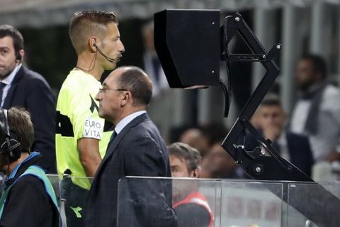 Referee Davide Massa watches the VAR during the Serie A soccer match between Inter Milan and Cagliari at the San Siro Stadium, in Milan, Italy, Saturday, Sept. 29, 2018. (AP Photo/Antonio Calanni)