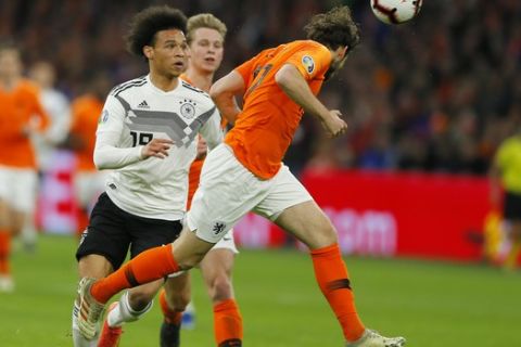 Germany's Leroy Sane, left, challenges for the ball with Netherlands' Daley Blind during the Euro 2020 group C qualifying soccer match between Netherlands and Germany at the Johan Cruyff ArenA in Amsterdam, Sunday, March 24, 2019. (AP Photo/Peter Dejong)