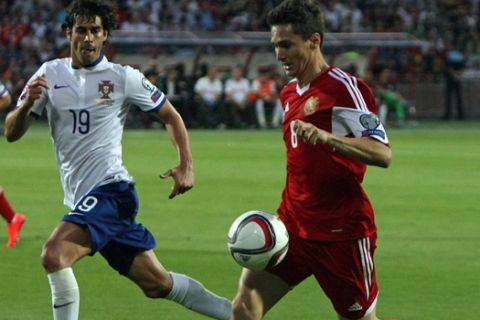 Armenias Marcos Pizzelli, right, fights for the ball with Portugal's Tiago, during the Euro 2016 Group I qualifying match between Armenia and Portugal in Yerevan, Armenia, Saturday, June 13, 2015. (Varo Rafayelyan, PAN Photo, via AP)