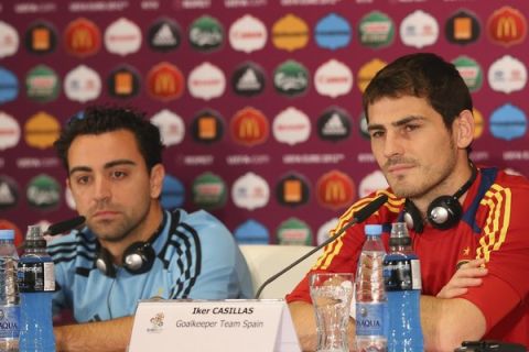 In this handout image provided by UEFA Spain's Xavi Hernandez, left, and Spain goalkeeper Iker Casillas talk to the media during a Euro 2012 soccer championship press conference at the Olympic Stadium in Kiev, Ukraine, Saturday, June 30, 2012, on the eve of the final between Spain and Italy.  (AP Photo/UEFA via Getty Images)
