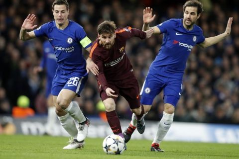 Barcelona's Lionel Messi, center, keeps the ball as Chelsea's Cesar Azpilicueta, left, and his teammate Cesc Fabregas try to stop him during the Champions League, round of 16, first-leg soccer match between Chelsea and Barcelona at Stamford Bridge stadium, Tuesday, Feb. 20, 2018. (AP Photo/Frank Augstein)
