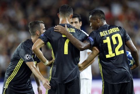 Juventus forward Cristiano Ronaldo talks to teammates Alex Sandro, right, and Miralem Pjanic after receiving a red card during the Champions League, group H soccer match between Valencia and Juventus, at the Mestalla stadium in Valencia, Spain, Wednesday, Sept. 19, 2018. (AP Photo/Alberto Saiz)
