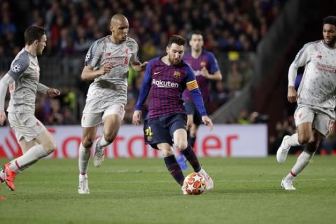 Barcelona's Lionel Messi, second right, goes for the ball between Liverpool's Joe Gomez, right, Liverpool's Fabinho, second left, and Liverpool's Andy Robertson during the Champions League semifinal, first leg, soccer match between FC Barcelona and Liverpool at the Camp Nou stadium in Barcelona, Spain, Wednesday, May 1, 2019. (AP Photo/Emilio Morenatti)
