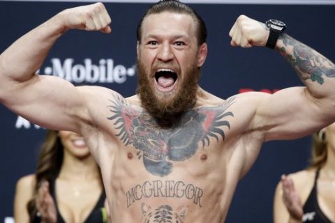 FILE - Conor McGregor poses during a ceremonial weigh-in for the UFC 246 mixed martial arts bout in Las Vegas, in this Friday, Jan. 17, 2020, file photo. The UFC intends to welcome a capacity crowd at Las Vegas' T-Mobile Arena on July 10, 2021, when Dustin Poirier and Conor McGregor fight for the third time. UFC President Dana White announced his plan Wednesday, April 14, 2021, for the promotion's first sellout show in its hometown since the start of the coronavirus pandemic.(AP Photo/John Locher, File)