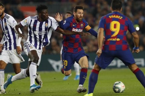 Barcelona's Lionel Messi controls the ball past Valladolid's Mohammed Salisu during the Spanish La Liga soccer match between FC Barcelona and Valladolid CF at the Camp Nou stadium in Barcelona, Spain, Tuesday, Oct. 29, 2019. (AP Photo/Joan Monfort)