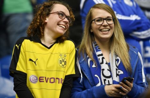 A Schalke and Dortmund supporter smile together prior the German Bundesliga soccer match between FC Schalke 04 and Borussia Dortmund in Gelsenkirchen, Saturday, April 1, 2017. (AP Photo/Martin Meissner)
