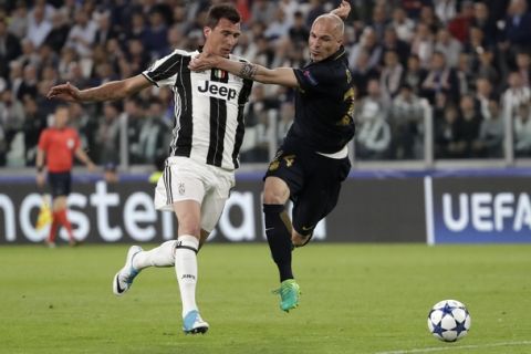 Juventus' Mario Mandzukic, left, and Monaco's Andrea Raggi challenge for the ball during the Champions League semi final second leg soccer match between Juventus and Monaco in Turin, Italy, Tuesday, May 9, 2017. (AP Photo/Luca Bruno)