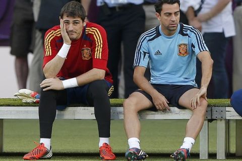 Spain's national soccer goalkeeper Iker Casillas (L) and Xavi Hernandez wait to start a training session at the Olympic stadium in Kiev, June 30, 2012. Italy will play against Spain in the Euro 2012  final in Kiev on Sunday.     REUTERS/Darren Staples (UKRAINE  - Tags: SPORT SOCCER)  
