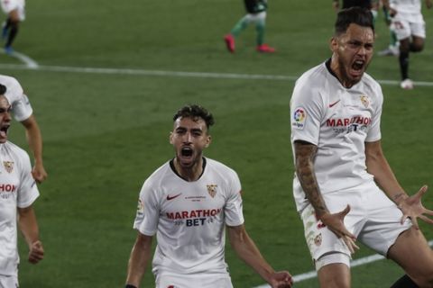 Sevilla's Lucas Ocampos celebrates after scoring against Betis during their Spanish La Liga soccer match in Seville, Spain, Thursday, June 11, 2020. With virtual crowds, daily matches and lots of testing for the coronavirus, soccer is coming back to Spain. The Spanish league resumes this week more than three months after it was suspended because of the pandemic, becoming the second top league to restart in Europe. The Bundesliga was first. The Premier League and the Italian league should be next in the coming weeks. (AP Photo)