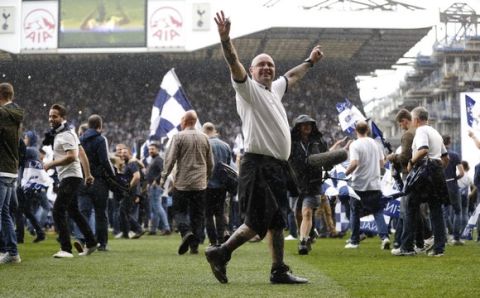Fans invade the pitch after the English Premier League soccer match between Tottenham Hotspur and Manchester United at White Hart Lane stadium in London, Sunday, May 14, 2017. It was the last Spurs match at the old stadium, a new stadium is being built on the site. (AP Photo/Frank Augstein)