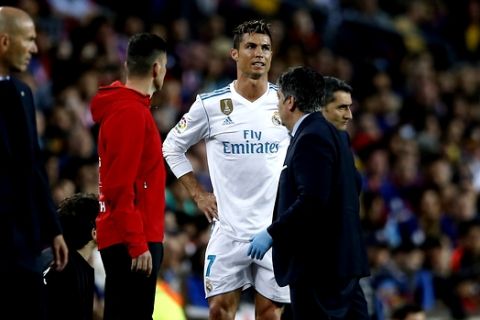 Real Madrid's Cristiano Ronaldo waits to come back on after treatment for an injury during a Spanish La Liga soccer match between Barcelona and Real Madrid, dubbed 'el clasico', at the Camp Nou stadium in Barcelona, Spain, Sunday, May 6, 2018. (AP Photo/Manu Fernandez)