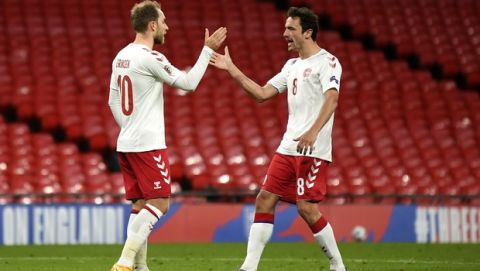 Denmark's Christian Eriksen, left, is congratulated by teammate Thomas Delaney after scoring his team's first goal during the UEFA Nations League soccer match between England and Denmark at Wembley Stadium in London, England, Wednesday, Oct. 14, 2020. (Daniel Leal-Olivas/Pool via AP)