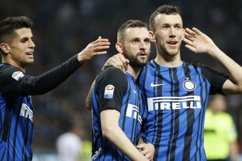 Inter Milan's Marcelo Brozovic celebrates with teammates Joao Cancelo, left, and van Perisic after scoring his side's third goal during an Italian Serie A soccer match between Inter Milan and Cagliari, at the San Siro stadium in Milan, Italy, Tuesday, April 17, 2018. (AP Photo/Antonio Calanni)