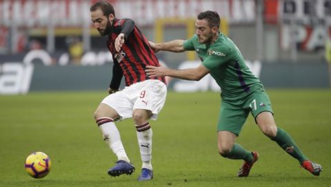 AC Milan's Gonzalo Higuain , left, challenges for the ball with Fiorentina's Jordan Veretout during a Serie A soccer match between AC Milan and Fiorentina, at the San Siro stadium in Milan, Italy, Saturday, Dec. 22, 2018. (AP Photo/Luca Bruno)