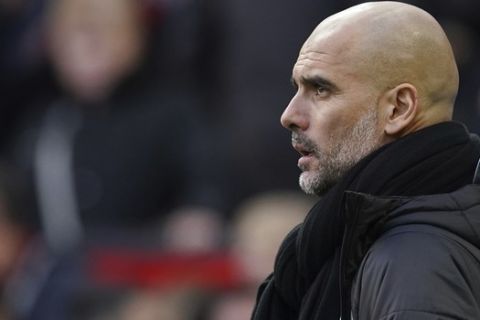 Manchester City's head coach Pep Guardiola watches the English Premier League soccer match between Manchester United and Manchester City at Old Trafford in Manchester, England, Sunday, March 8, 2020. (AP Photo/Dave Thompson)