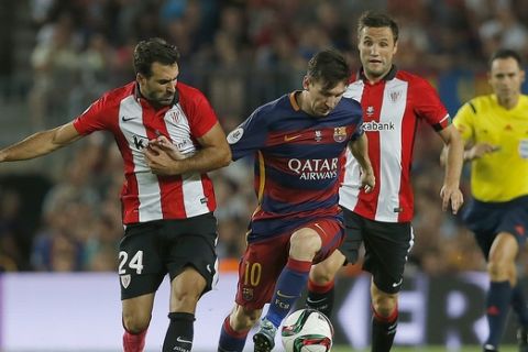Barcelona's Lionel Messi, center, and Athletic Bilbao's Mikel Balenziaga challenge for the ball during the second leg Spanish Super Cup soccer match between FC Barcelona and Athletic Bilbao at the Camp Nou stadium in Barcelona, Spain, Monday, Aug.17, 2015. (AP Photo/Emilio Morenatti)