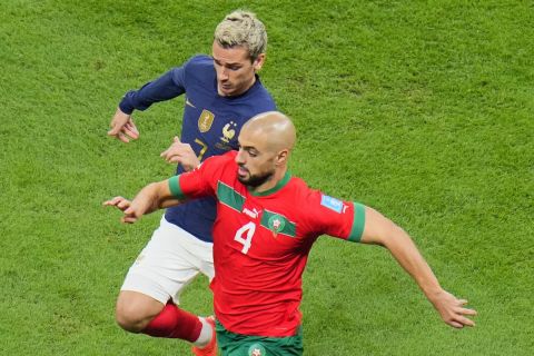 Morocco's Sofyan Amrabat, front, and France's Antoine Griezmann fight for the ball during the World Cup semifinal soccer match between France and Morocco at the Al Bayt Stadium in Al Khor, Qatar, Wednesday, Dec. 14, 2022. (AP Photo/Hassan Ammar)