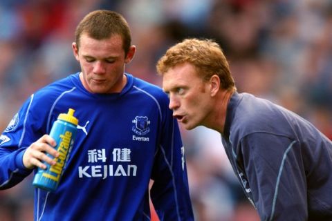 Everton's Wayne Rooney has a drink as his manager David Moyes (l) gives him instructions