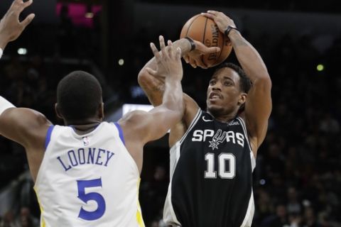 San Antonio Spurs guard DeMar DeRozan (10) shoots over Golden State Warriors forward Kevon Looney (5) during the second half of an NBA basketball game, Sunday, Nov. 18, 2018, in San Antonio. San Antonio won 104-92. (AP Photo/Eric Gay)