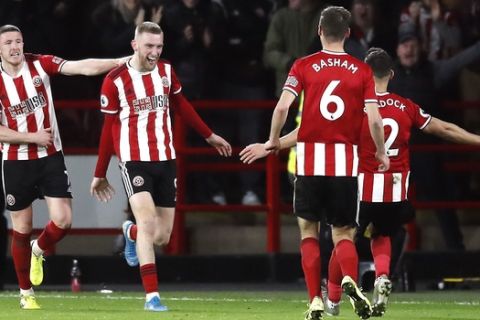 Sheffield United's Oliver McBurnie, second left, celebrates scoring his sides first goal of the game during the English Premier League soccer match between West Ham United and Sheffield United at Bramall Lane, Sheffield, England, Friday, Jan. 10, 2020. (Martin Rickett/PA via AP)
