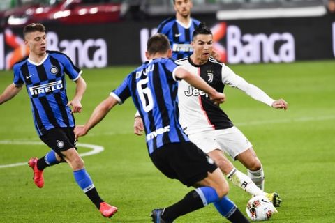 Inter Milan's Stefan de Vrij , left, and Juventus' Cristiano Ronaldo battle for the ball during the Serie A soccer match between Inter Milan and Juventus at the Allianz Stadium in Turin, Italy, Sunday March 8, 2020. The match was played to a closed stadium as a measure against coronavirus contagion. (Marco Alpozzi/LaPresse via AP)