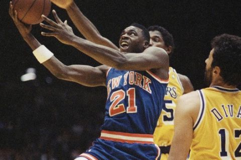 New York Knicks' Gerald Wilkins (21) goes up for a basket as Los Angeles Lakers A.C. Green, background, reaches over to hinder the effort, with teammate Vlade Divac (12) moving in to help, during NBA action in Inglewood, Calif., Dec. 4, 1989. The Lakers downed the Knicks 115-104. (AP Photo/Alan Greth)