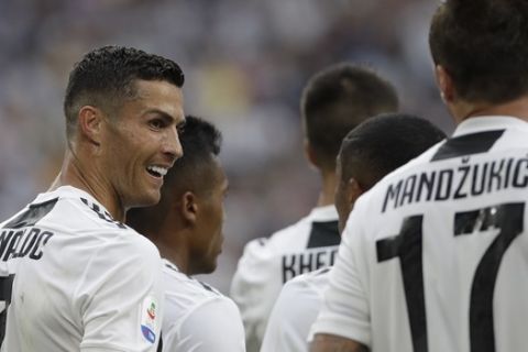 Juventus' Cristiano Ronaldo, left looks back at his teammate and scorer of his sides 2nd goal Mario Mandzukic as they celebrate during the Serie A soccer match between Juventus and Lazio at the Allianz Stadium in Turin, Italy, Saturday, Aug. 25, 2018. (AP Photo/Luca Bruno)