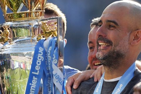 Manchester City coach Pep Guardiola lifts the English Premier League trophy after the English Premier League soccer match between Brighton and Manchester City at the AMEX Stadium in Brighton, England, Sunday, May 12, 2019. Manchester City defeated Brighton 4-1 to win the championship. (AP Photo/Frank Augstein)