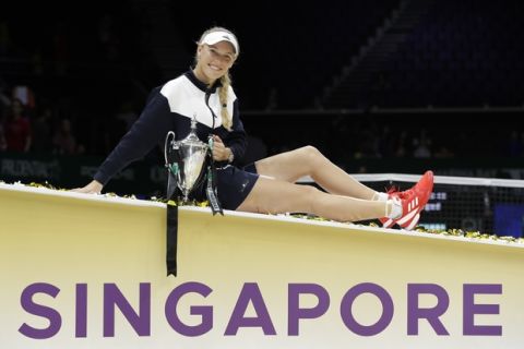 Caroline Wozniacki of Denmark poses with the winner's trophy after beating Venus Williams of the United States during their singles final match at the WTA tennis tournament in Singapore, on Sunday, Oct. 29, 2017. (AP Photo/Yong Teck Lim)