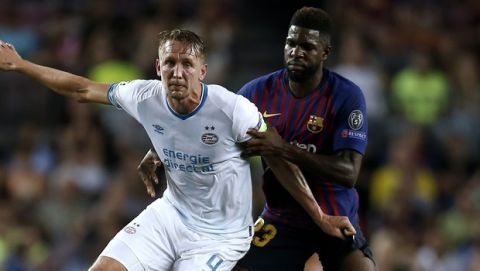 PSV's Luuk de Jong, left, controls the ball as Barcelona defender Samuel Umtiti holds him during the group B Champions League soccer match between FC Barcelona and PSV Eindhoven at the Camp Nou stadium in Barcelona, Spain, Tuesday, Sept. 18, 2018. (AP Photo/Manu Fernandez)