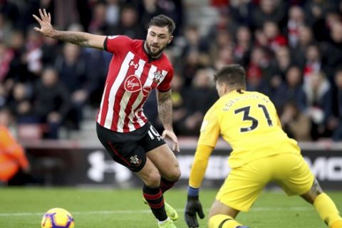 Southampton's Charlie Austin, left, tries to reach the ball ahead of Manchester City goalkeeper Ederson, during their English Premier League soccer match at St Mary's Stadium in Southampton, England, Sunday Dec. 30, 2018. (Adam Davy/PA via AP)