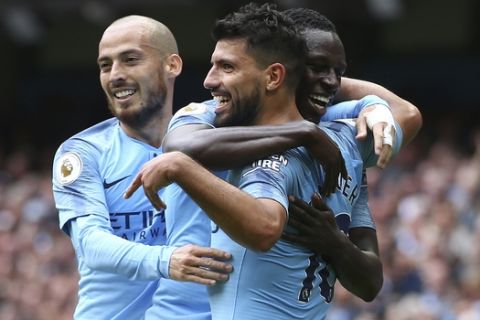 Manchester City's Sergio Aguero celebrates scoring his side's third goal of the game with David Silva, left, and Benjamin Mendy during the English Premier League soccer match between Manchester City and Huddersfield Town at the Etihad Stadium in Manchester, England, Sunday, Aug. 19, 2018. (AP Photo/Dave Thompson)