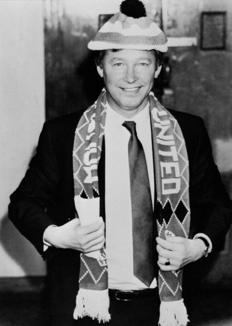 Manchester United's new manager Alex Ferguson at a press conference at Old Trafford, decked out in his new team's colours.