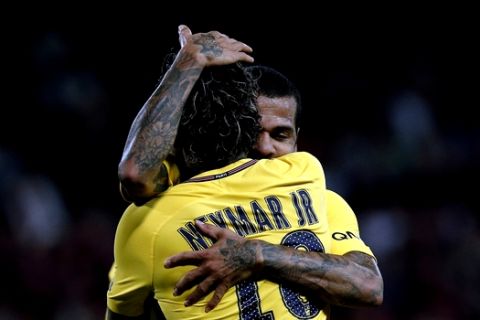 PSG's Neymar, back to camera, is congratulated by teammate Dani Alves after Neymar scored his side's 3rd goal during the French League One soccer match between Guingamp and PSG at the Roudourou stadium in Guingamp, western France, Sunday, Aug. 13, 2017. Neymar makes his long-awaited debut with Paris Saint-Germain on Sunday in the small Brittany town of Guingamp. (AP Photo/Kamil Zihnioglu)