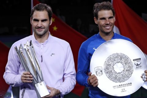 Winner's Roger Federer of Switzerland, left, holding the winner's trophy and Rafael Nadal of Spain pose with their trophies after the award ceremony for the Shanghai Masters tennis tournament at Qizhong Forest Sports City Tennis Center in Shanghai, China, Sunday, Oct. 15, 2017. Federer defeated Nadal to win the tournament. (AP Photo/Andy Wong)