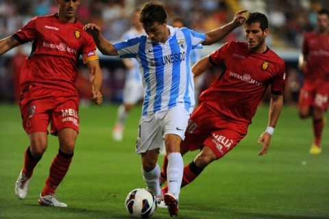 Mallorca's Portuguese defender Jose Nunes (L) and Israeli forward Tomer Hemed (R) fight for the ball with Malaga's Uruguayan forward Sebastian Fernandez (C) on August 25, 2012 during a Spanish League football match at the Rosaleda stadium in Malaga.  AFP PHOTO/ JORGE GUERRERO        (Photo credit should read Jorge Guerrero/AFP/GettyImages)
