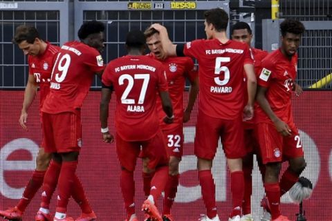 Munich's scorer Joshua Kimmich, center, and his teammats celebrate the opening goal during the German Bundesliga soccer match between Borussia Dortmund and FC Bayern Munich in Dortmund, Germany, Tuesday, May 26, 2020. The German Bundesliga is the world's first major soccer league to resume after a two-month suspension because of the coronavirus pandemic. (Federico Gambarini/DPA via AP, Pool)