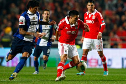 Benfica´s argentinian midfield  player Nicolas Gaitan(C) fights for the ball with FC Porto argentinian midfielder Lucho Gonzalez (L) during their first league soccer match held at Luz Stadium in Lisbon, 13 January 2013. MIGUEL A. LOPES/LUSA