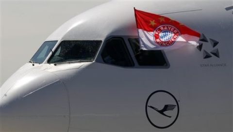 An FC Bayern Munich flag waves from the cockpit of the airplane that flew the team back from Madrid after landing at the airport of Munich, Germany, Thursday, April 26, 2012. Munich won the Champions League semi-final against real Madrid. The final will take place between Bayern Munich and FC Chelsea on May 19, 2012, in Munich. (AP Photo/Matthias Schrader)