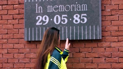 A girl walks past a sign to commemorate people who lost their lives in 1985 at the King Baudouin stadium in Brussels, Belgium, Wednesday, June 14, 2000. Thirty-nine people, most of them Italians, died on May 29, 1985 prior to the Champions Cup final between Juventus and Liverpool at the King Baudouin stadium, then called the Heysel  stadium, when a low retaining wall collapsed under the weight of fans fleeing from Liverpool supporters. English soccer clubs were banned from European cup competition for 5 years.(AP Photo/Luca Bruno)