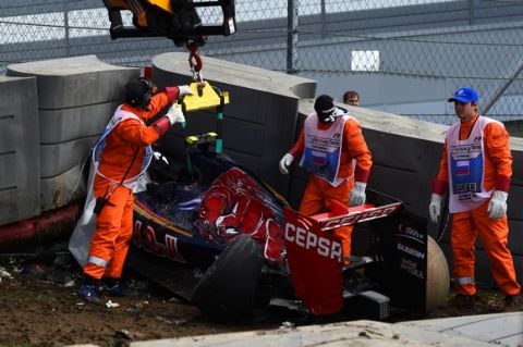 SOCHI, RUSSIA - OCTOBER 10:  Course marshalls remove Carlos Sainz of Spain and Scuderia Toro Rosso's damaged car after he crashed during final practice for the Formula One Grand Prix of Russia at Sochi Autodrom on October 10, 2015 in Sochi, Russia.  (Photo by Lars Baron/Getty Images)