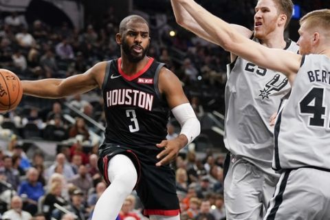 Houston Rockets' Chris Paul (3) looks to pass the ball as San Antonio Spurs' Davis Bertans (42) and Jakob Poeltl defend during the first half of an NBA basketball game Friday, Nov. 30, 2018, in San Antonio. (AP Photo/Darren Abate)