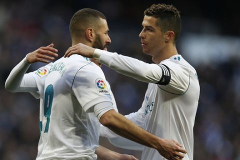 Real Madrid's Karim Benzema, left, celebrates with teammate Cristiano Ronaldo after scoring their side's fourth goal against Alaves during the Spanish La Liga soccer match between Real Madrid and Alaves at the Santiago Bernabeu stadium in Madrid, Saturday, Feb. 24, 2018. Ronaldo scored twice and Benzema once in Real Madrid's 4-0 victory. (AP Photo/Francisco Seco)