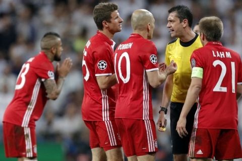 Bayern players argue with Referee Viktor Kassai after he showed a second yellow card to Arturo Vidal, left, during the Champions League quarterfinal second leg soccer match between Real Madrid and Bayern Munich at Santiago Bernabeu stadium in Madrid, Spain, Tuesday April 18, 2017. (AP Photo/Daniel Ochoa de Olza)