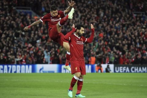 Liverpool's Mohamed Salah, right, celebrates scoring his side's second goal of the game with Roberto Firmino  against Roma during their Champions League, Semifinal first leg soccer match at Anfield, Liverpool, England, Tuesday April 24, 2018. (Peter Byrne/PA via AP)