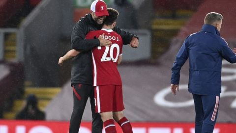 Liverpool's manager Jurgen Klopp, left, embraces Liverpool's Diogo Jota after their English Premier League soccer match between Liverpool and Arsenal at Anfield in Liverpool, England, Monday, Sept. 28, 2020. (Laurence Griffiths/Pool via AP)